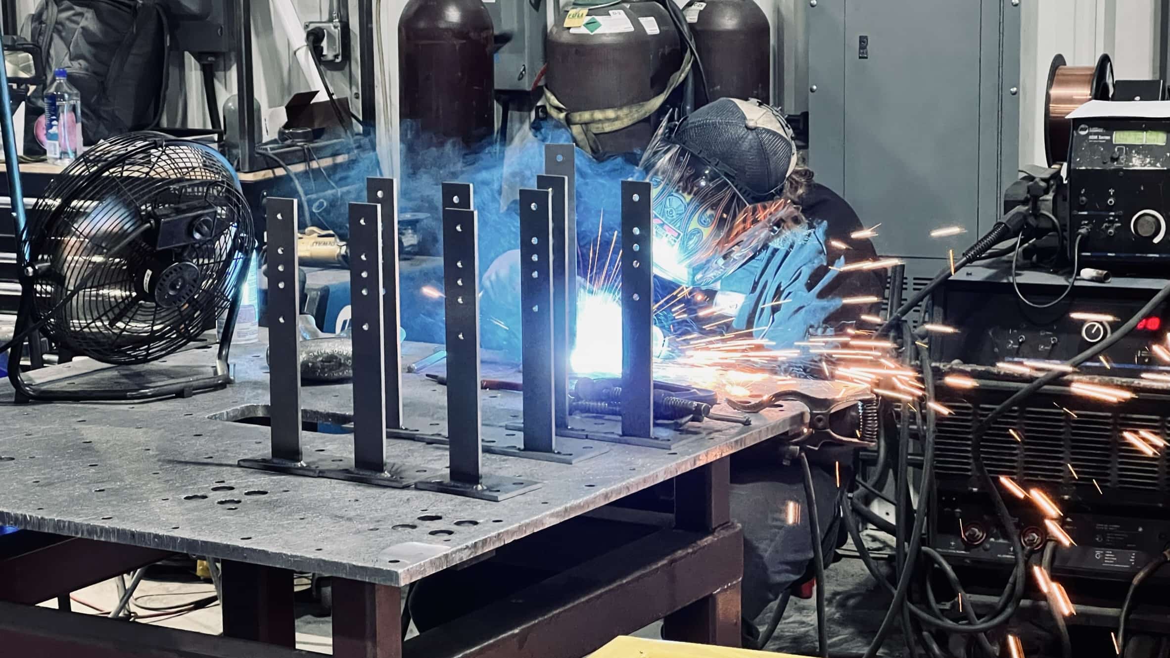 Welder creating sparks while working on a fabrication